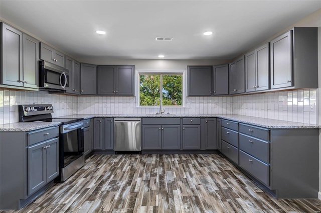 kitchen featuring sink, appliances with stainless steel finishes, gray cabinetry, and dark hardwood / wood-style flooring