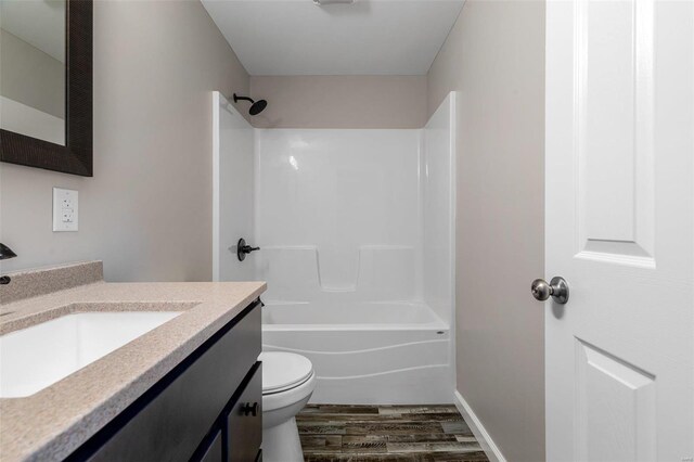 full bathroom featuring vanity, toilet,  shower combination, and hardwood / wood-style floors