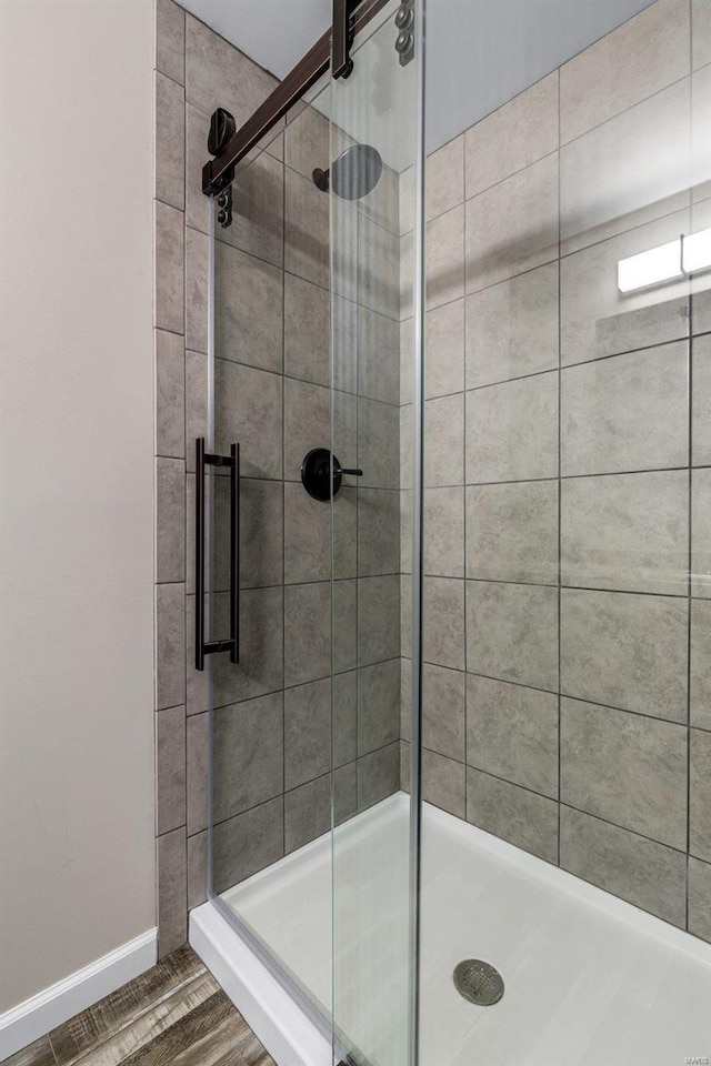 bathroom featuring hardwood / wood-style flooring and an enclosed shower