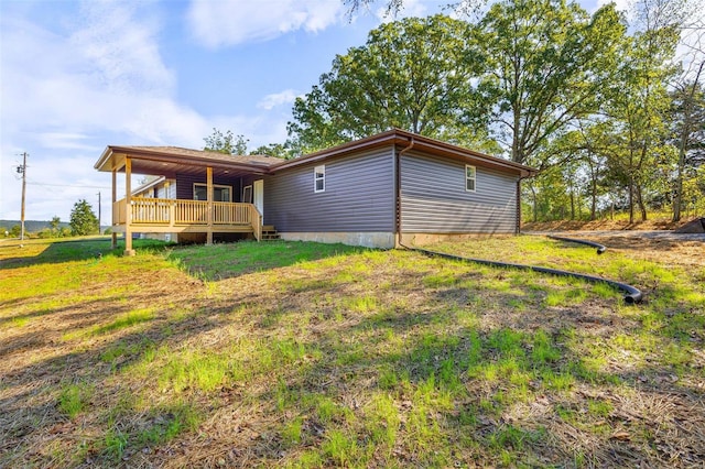 back of property with a yard and a deck