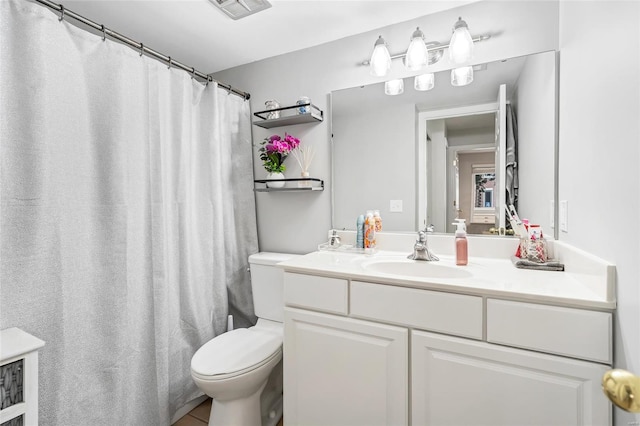 bathroom featuring toilet, vanity, and a shower with shower curtain