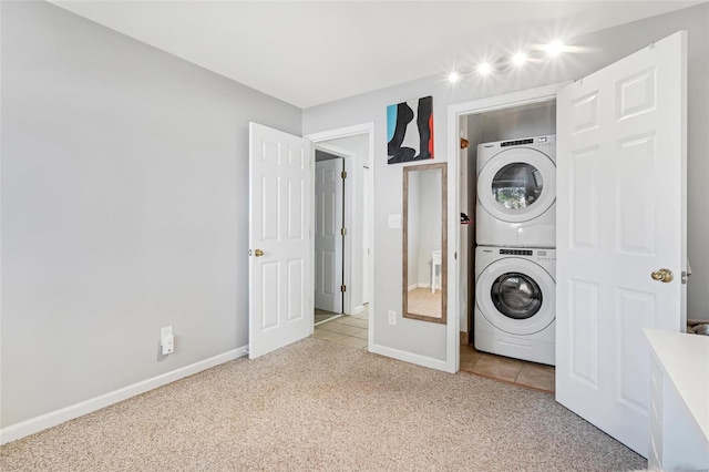 clothes washing area with light carpet and stacked washing maching and dryer