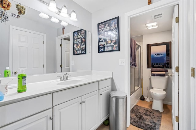 full bathroom with tile patterned flooring, shower / bath combination with glass door, vanity, and toilet