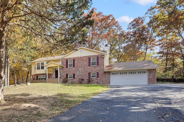 bi-level home with a garage and a front lawn