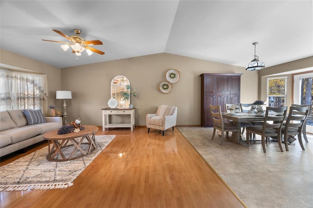 living room featuring light hardwood / wood-style floors, ceiling fan, vaulted ceiling, and a wealth of natural light