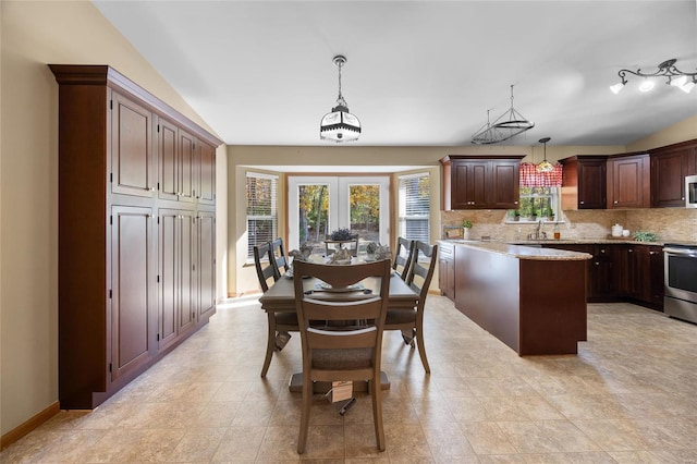 dining room featuring lofted ceiling, sink, and french doors