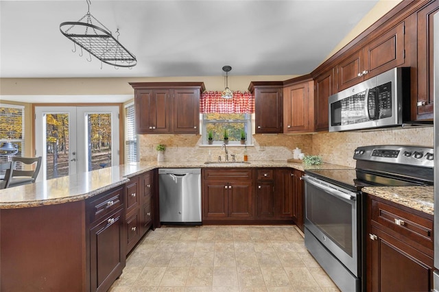 kitchen featuring sink, appliances with stainless steel finishes, hanging light fixtures, and kitchen peninsula