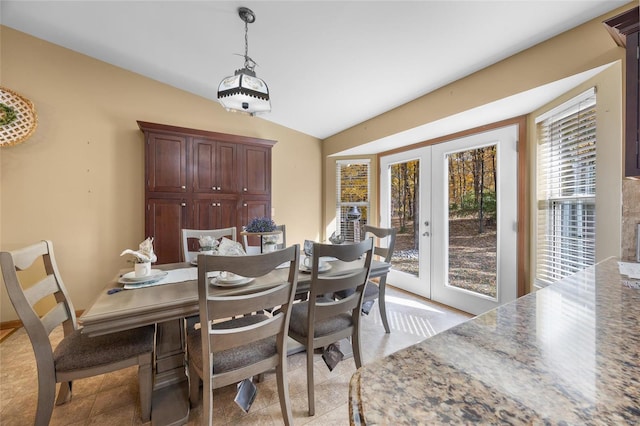 dining space featuring lofted ceiling and french doors