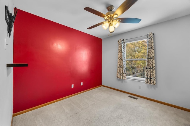 carpeted spare room with ceiling fan