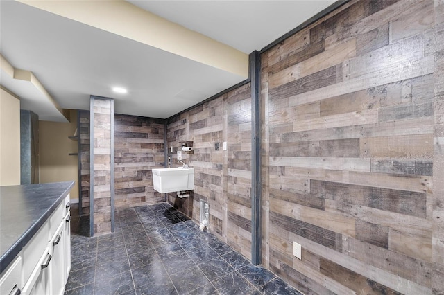 bathroom featuring vanity and wood walls