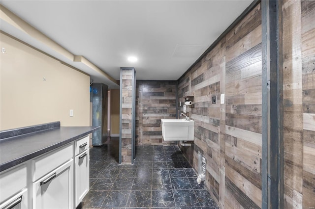 bathroom with tile walls, vanity, and wood walls