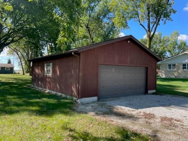 garage with a lawn and wood walls