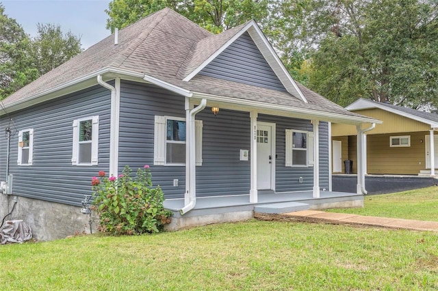 view of front facade featuring a porch, an attached carport, roof with shingles, and a front lawn
