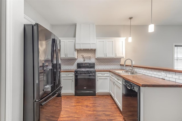 kitchen featuring decorative backsplash, a peninsula, white cabinetry, a sink, and black appliances