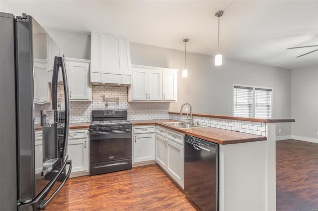 kitchen with pendant lighting, sink, kitchen peninsula, white cabinetry, and black appliances