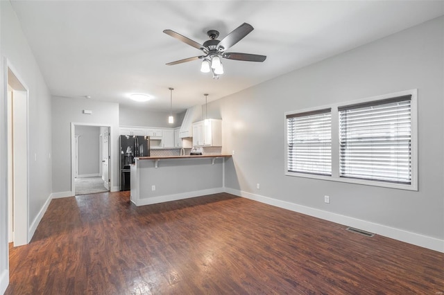 kitchen with ceiling fan, a peninsula, white cabinetry, visible vents, and dark wood-style floors
