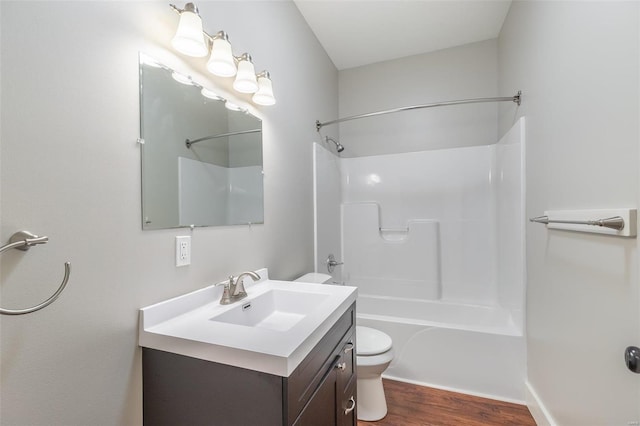 full bath with wood finished floors, tub / shower combination, toilet, and vanity