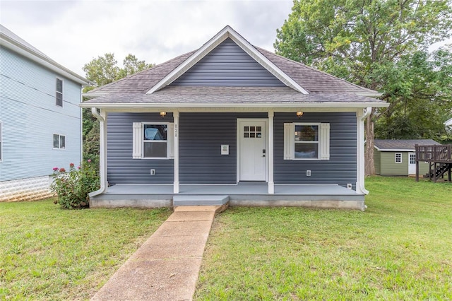 bungalow-style home featuring a porch, roof with shingles, and a front lawn