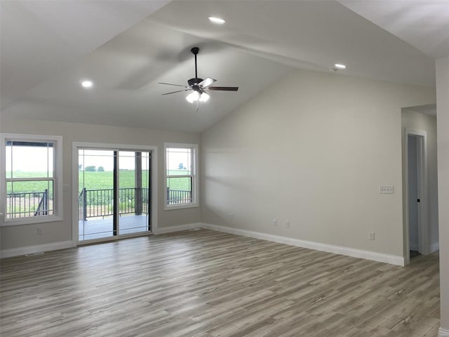 empty room with lofted ceiling, light hardwood / wood-style floors, and ceiling fan