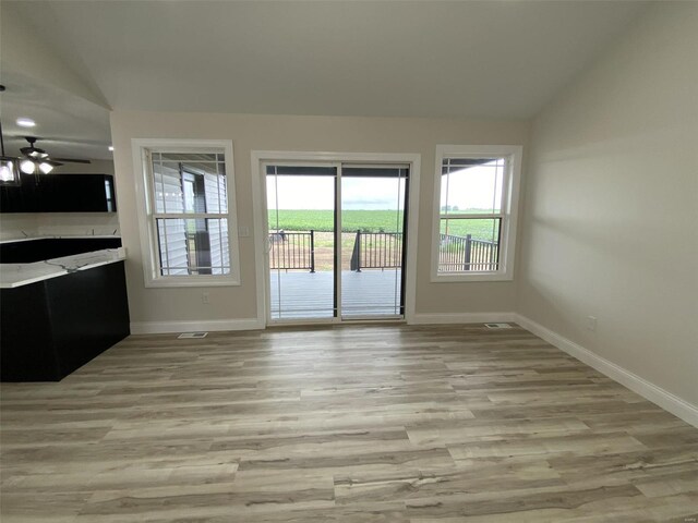 interior space with light hardwood / wood-style flooring, lofted ceiling, and ceiling fan