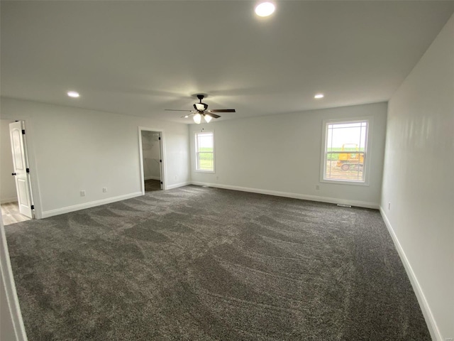 carpeted spare room with ceiling fan and plenty of natural light