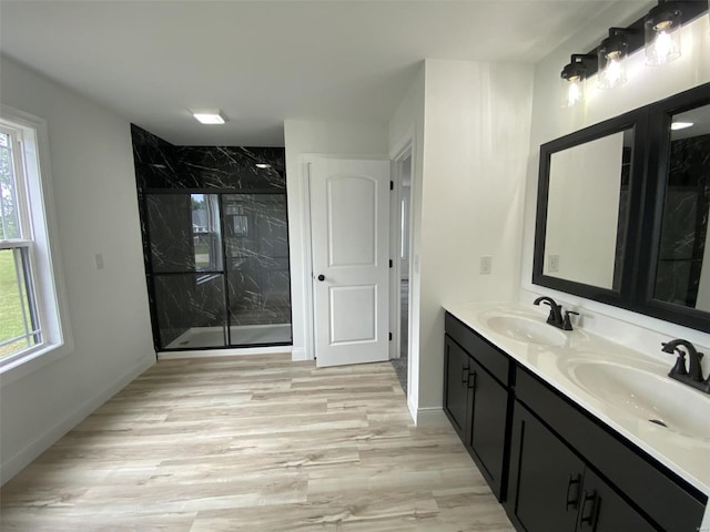 bathroom featuring vanity, hardwood / wood-style floors, a wealth of natural light, and a shower with shower door