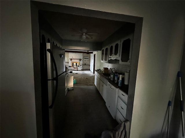 kitchen with stainless steel fridge, white cabinetry, white dishwasher, ceiling fan, and sink