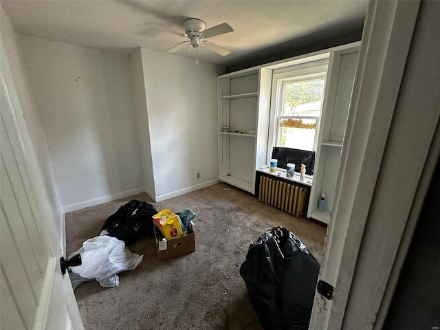 interior space with ceiling fan, carpet floors, and radiator heating unit