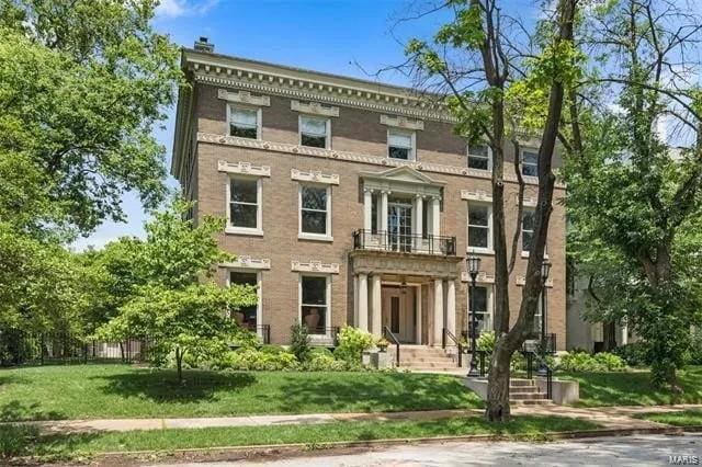 italianate house featuring a balcony and a front lawn