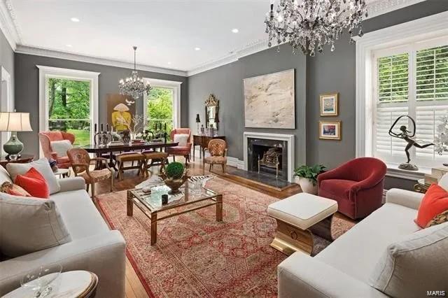 living room featuring wood-type flooring, ornamental molding, and a chandelier