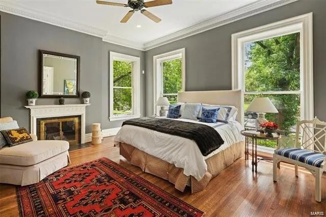 bedroom featuring wood-type flooring, crown molding, and ceiling fan