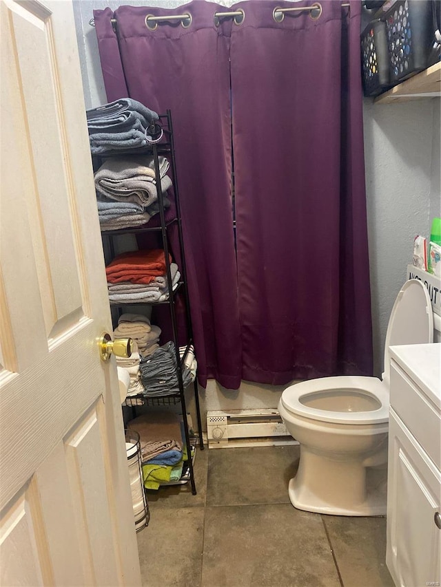 bathroom featuring baseboard heating, tile patterned flooring, vanity, and toilet