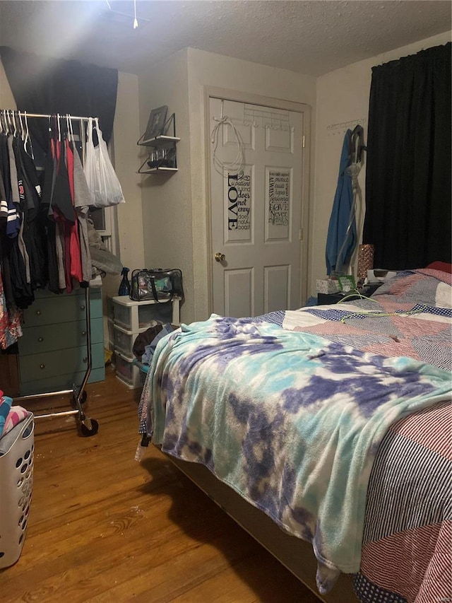 bedroom featuring a textured ceiling, hardwood / wood-style floors, and a closet