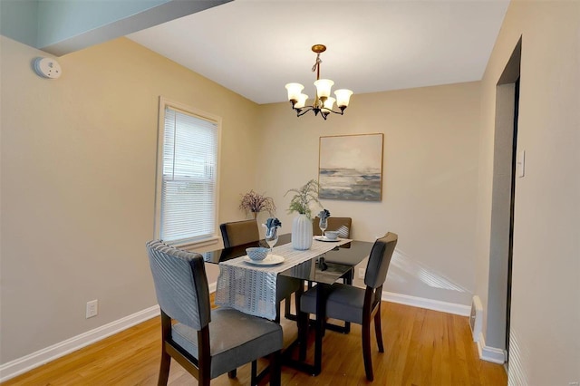 dining space featuring a notable chandelier and light hardwood / wood-style floors