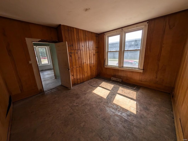 unfurnished bedroom with wooden walls and a closet