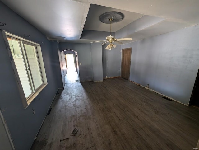 interior space featuring ceiling fan, a tray ceiling, and dark hardwood / wood-style flooring