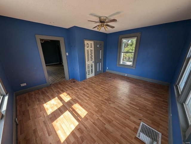 interior space featuring ceiling fan, hardwood / wood-style floors, and a textured ceiling