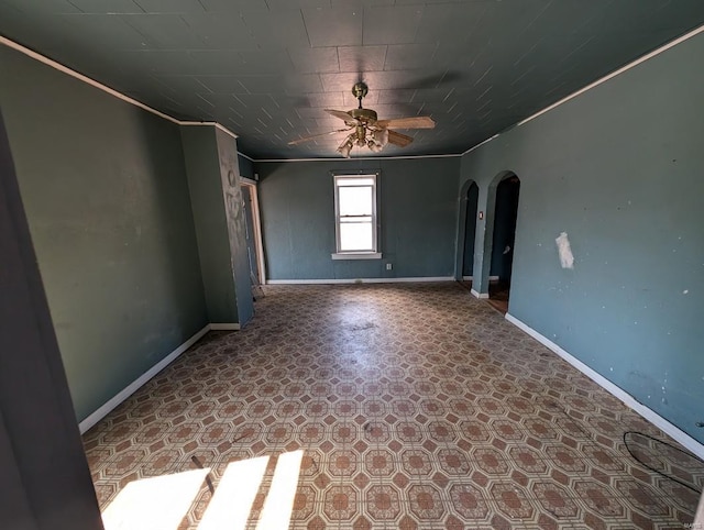 empty room featuring ceiling fan and ornamental molding