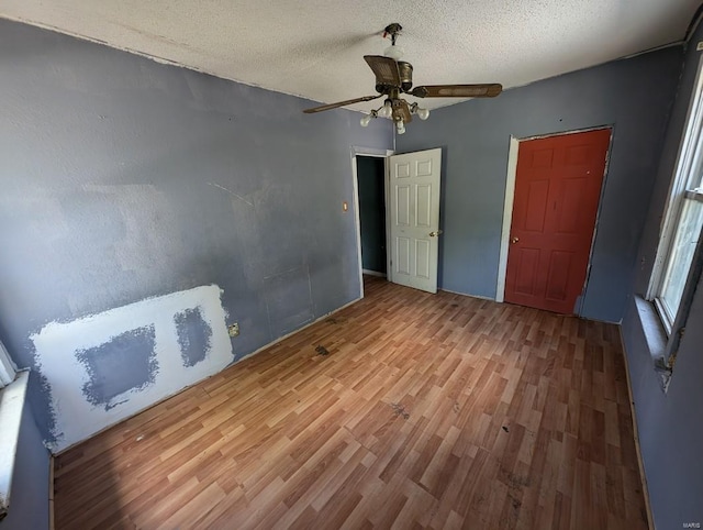 interior space featuring a textured ceiling, ceiling fan, and light hardwood / wood-style flooring