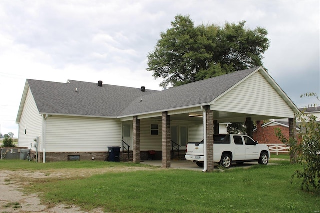 rear view of property with a lawn and a carport