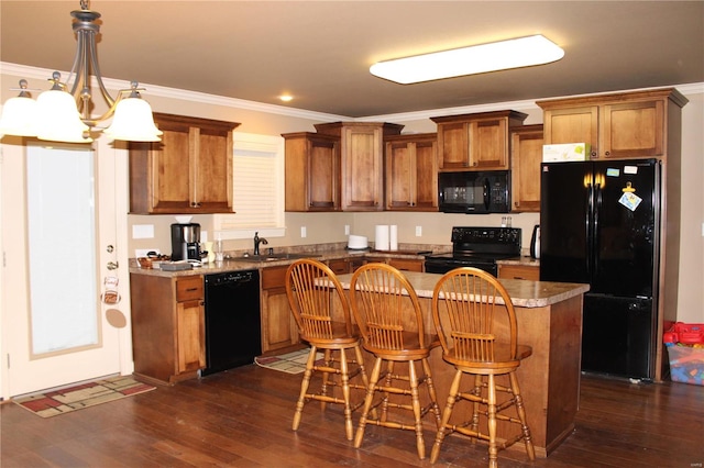 kitchen with black appliances, ornamental molding, a center island, and dark wood-type flooring