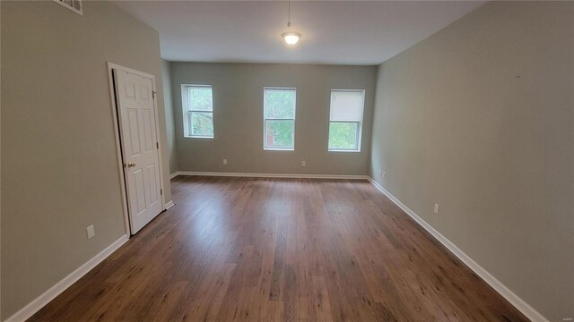 spare room featuring dark hardwood / wood-style floors and a wealth of natural light