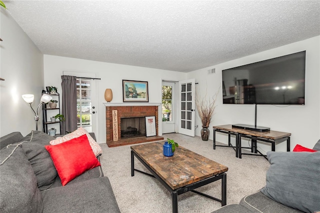 carpeted living room with a brick fireplace and a textured ceiling