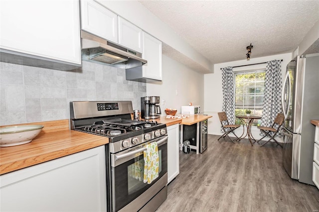 kitchen featuring light hardwood / wood-style floors, wooden counters, range hood, stainless steel appliances, and white cabinetry