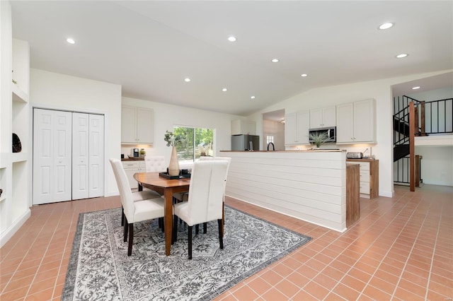 dining area with lofted ceiling and light tile patterned floors