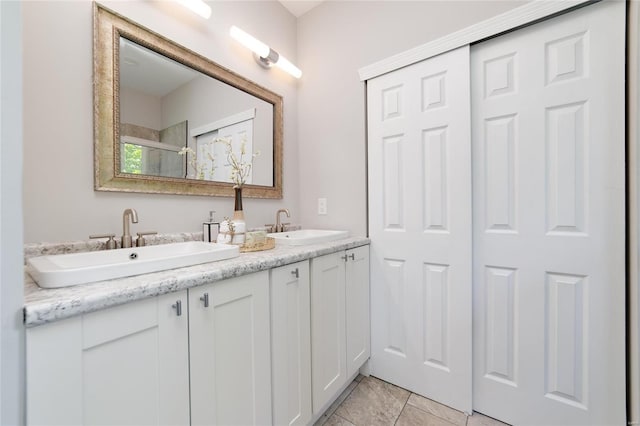 bathroom with tile patterned flooring, vanity, and a shower with shower door