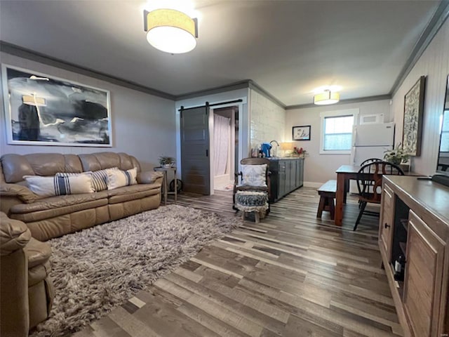 living room featuring dark wood-type flooring, crown molding, and a barn door