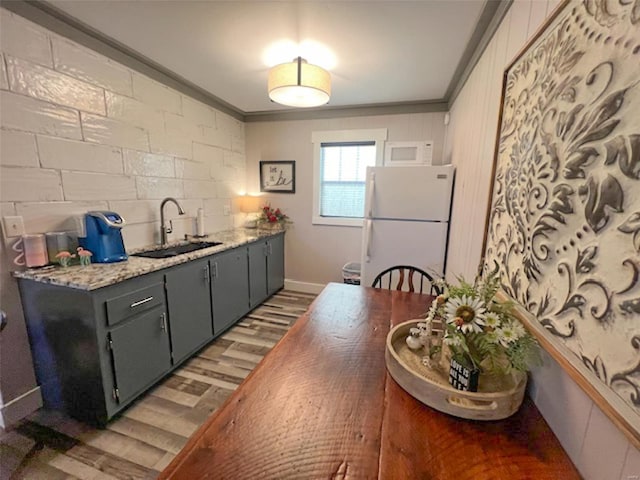 kitchen with dark hardwood / wood-style floors, gray cabinetry, white appliances, sink, and crown molding