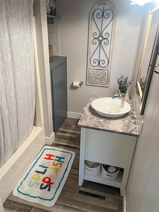 bathroom featuring wood-type flooring, vanity, and shower / tub combo