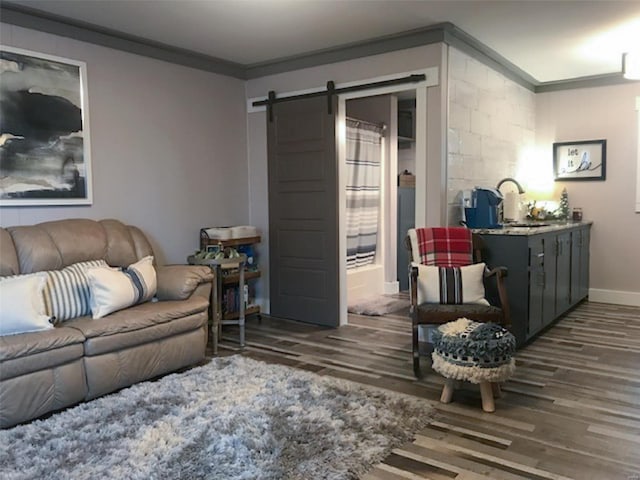 living room featuring crown molding, a barn door, and dark hardwood / wood-style floors